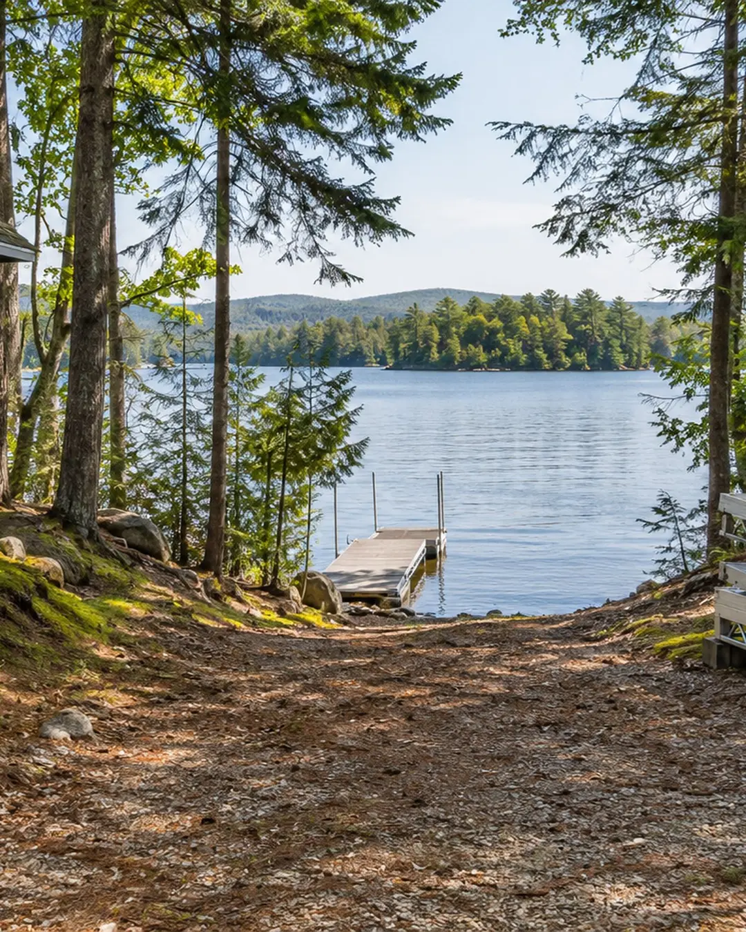Illustrative wooded path beside a camp and lake